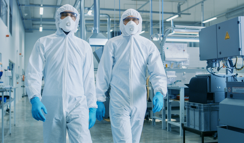 Two Engineers/ Scientists in Hazmat Sterile Suits Walking Through Technologically Advanced Factory/ Laboratory. Clean High-Tech Environment with CNC Machinery.